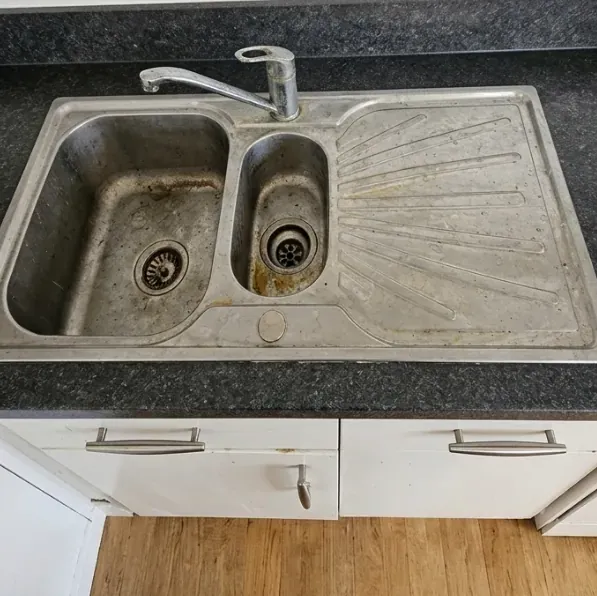 Kitchen sink before cleaning, dull with limescale and stains